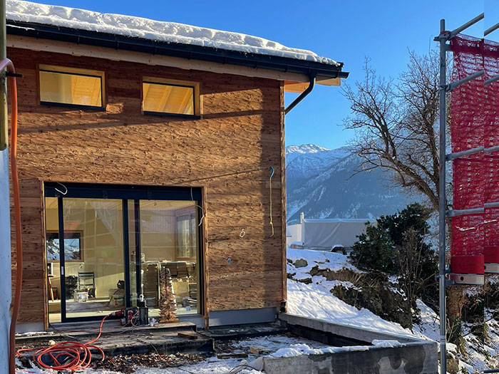 Moderne Holzbauweise im Schnee mit Bergblick