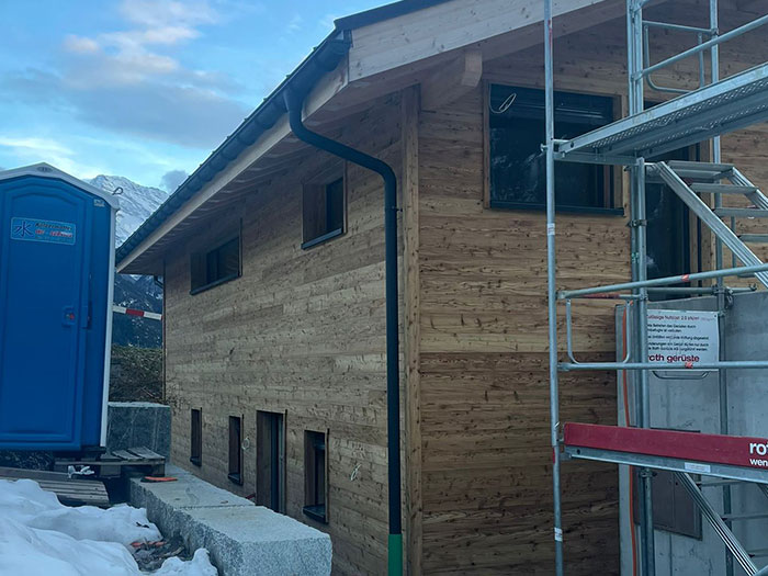 Modernes Holzhaus im Bau mit Baugerüst.