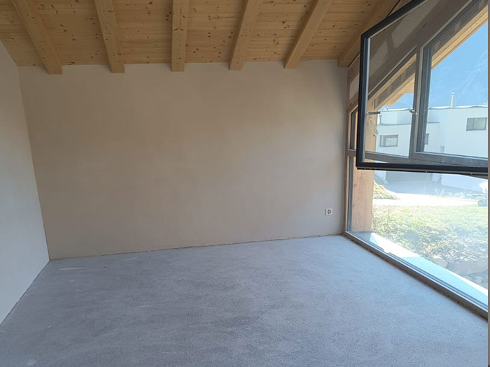 Helles Zimmer mit Holzdecke und großem Fenster.