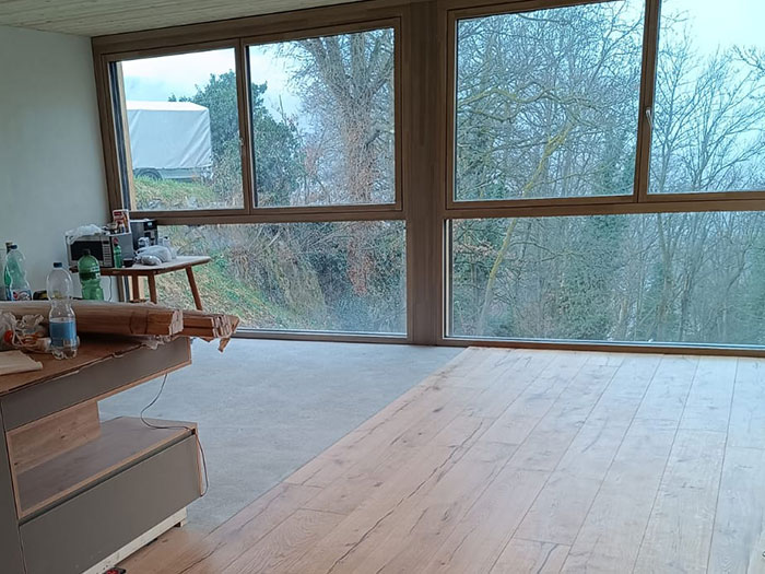 Helles Zimmer mit großen Fenstern und Holzfußboden