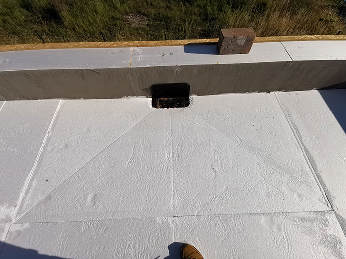 Weiße Dachfläche mit Regenablauf