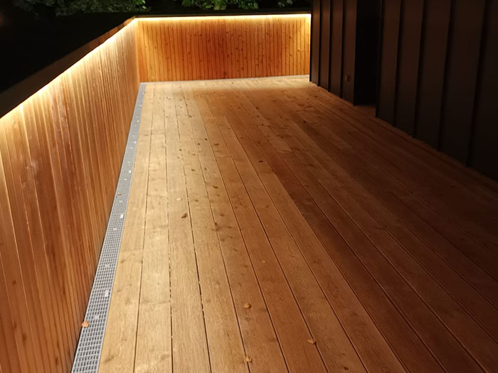 Holzterrasse mit indirekter Beleuchtung bei Nacht