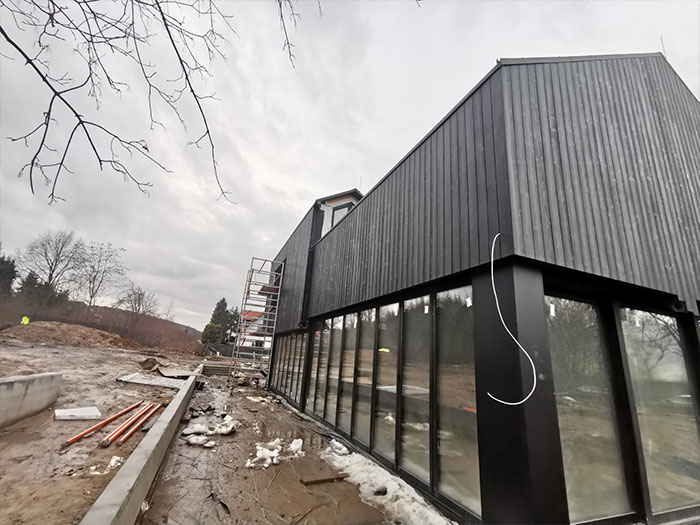 Moderne Baustelle mit schwarzem Holzhaus