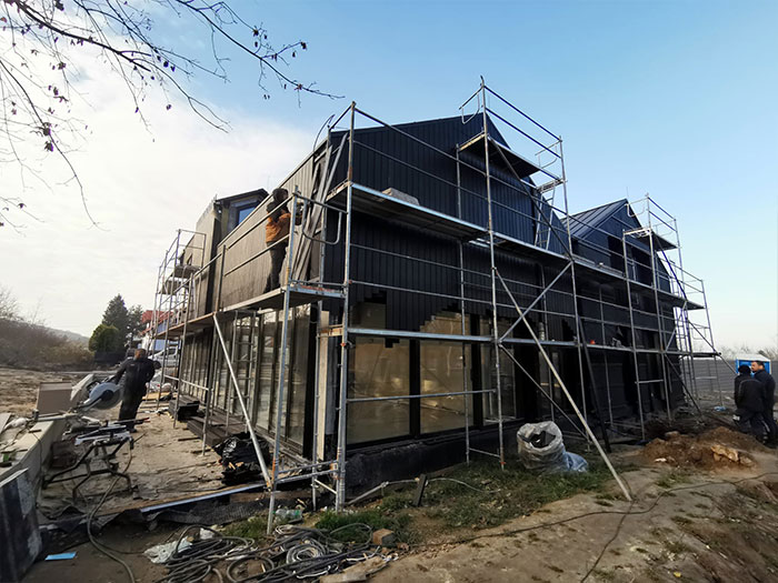 Hausbau mit Gerüst und Arbeitern im Freien